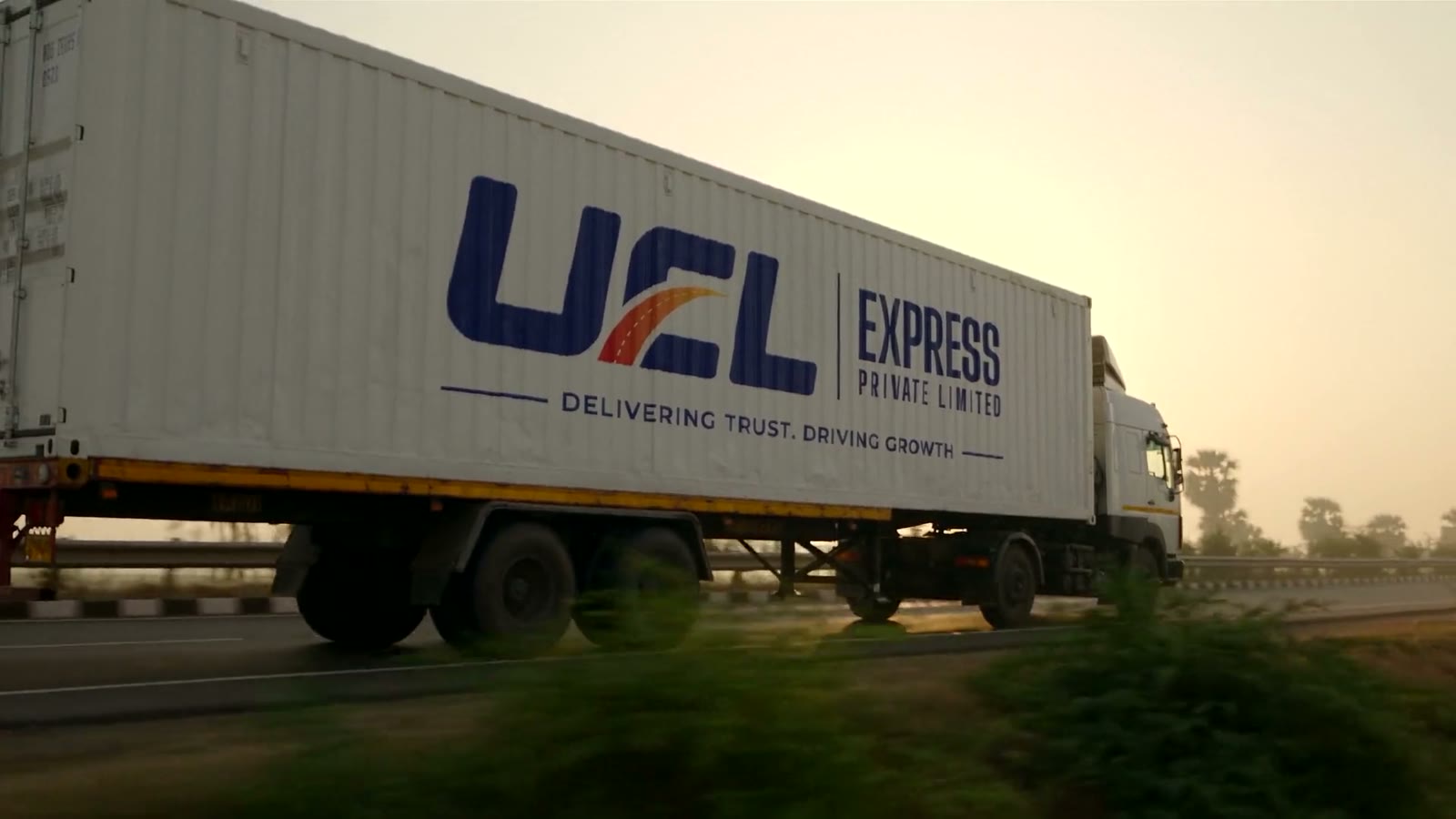 A UCL Express trailer on the highway at golden hour